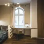 Modern studio apartment with workspace and large window in city center.