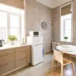 Bright kitchen with beige cabinets, white appliances, and dining area.