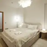 Elegant bedroom with neutral tones, soft lighting, and cozy furnishings.