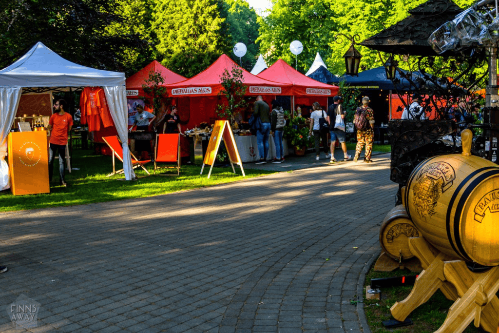 Rīgas alus un vīna pasākuma apmeklētāji, košas teltis un alus mucas.